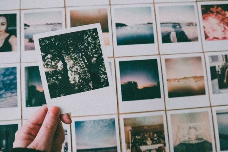 Dłoń trzymająca zdjęcie Polaroid wśród st
