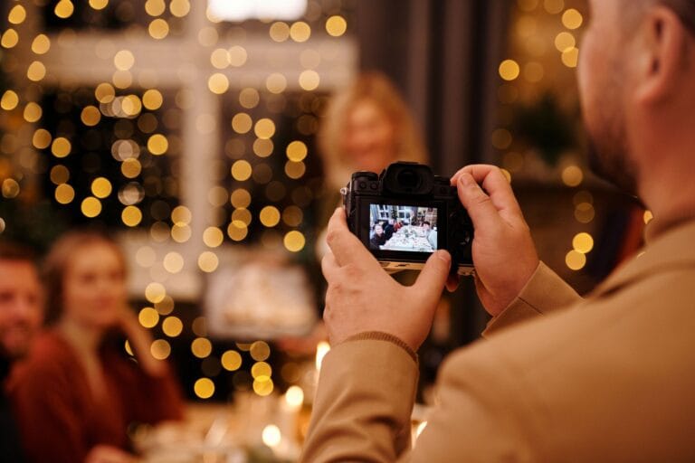 Mężczyzna fotografuje rodzinne spotkanie przy świątecznym stole